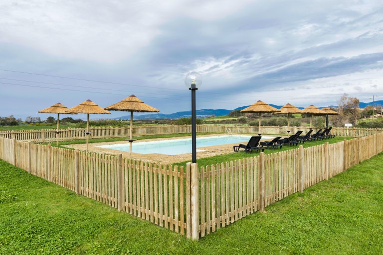 swimming pool with parasols and chairs